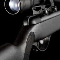 close-up of black air rifle with tactical scope on black background