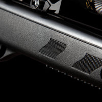 Close-up of textured black air rifle body with trigger and scope adjustment dial
