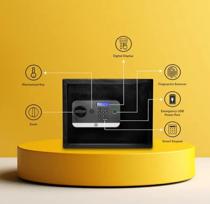 Black electronic safe with digital display, fingerprint scanner, keypad, USB port, and mechanical key on a yellow platform.